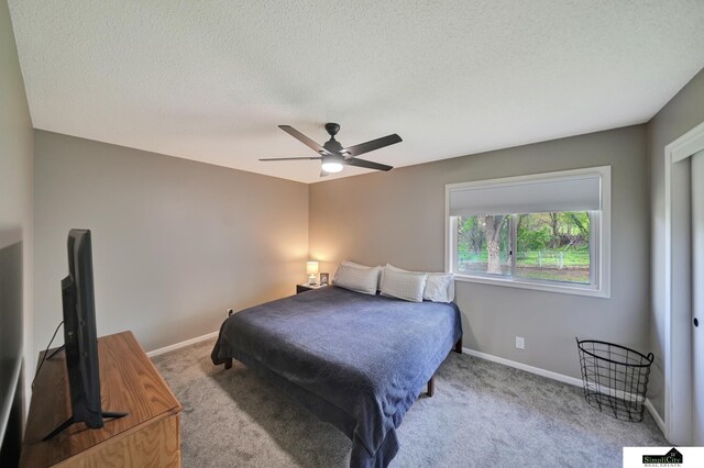 carpeted bedroom with baseboards, a ceiling fan, and a textured ceiling