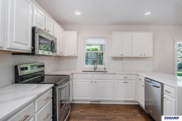 kitchen featuring stainless steel appliances, a sink, plenty of natural light, white cabinets, and recessed lighting