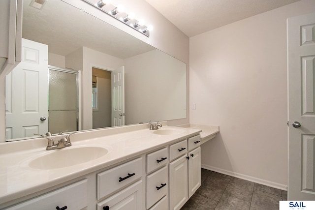 full bath featuring a shower stall, double vanity, baseboards, and tile patterned floors