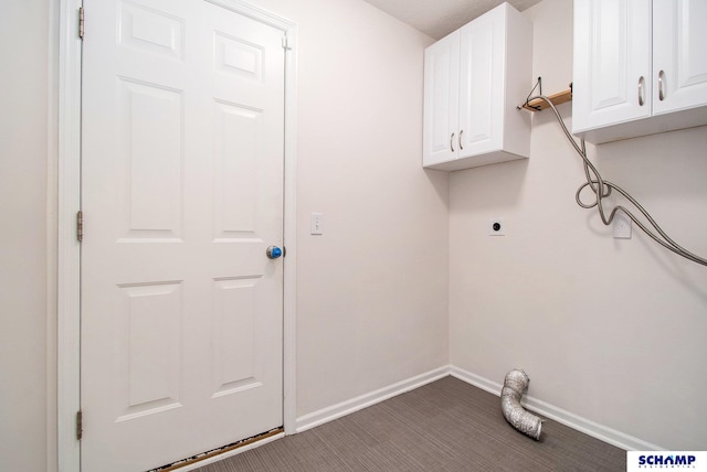 laundry area with hookup for an electric dryer, cabinet space, dark carpet, and baseboards