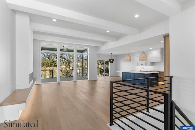 interior space featuring recessed lighting, beamed ceiling, a sink, and light wood-style floors