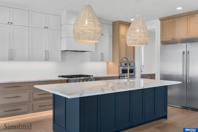kitchen with light wood-type flooring, recessed lighting, light stone counters, and stainless steel appliances