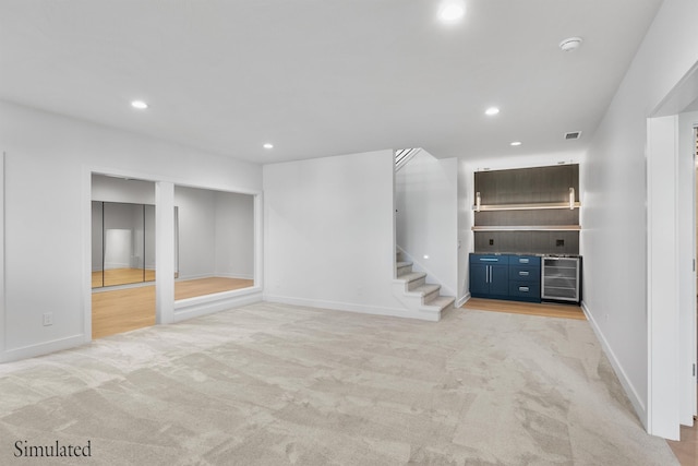 interior space featuring wine cooler, light carpet, recessed lighting, and stairs