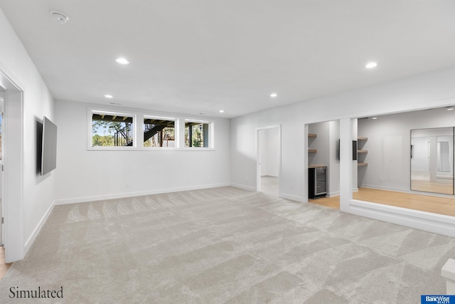 basement with baseboards, carpet flooring, recessed lighting, and beverage cooler