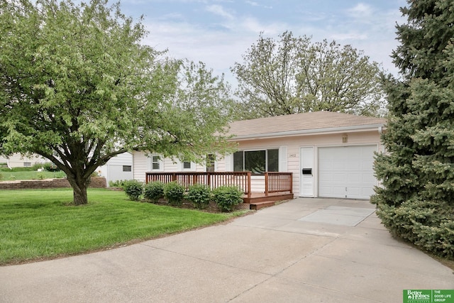 single story home featuring a wooden deck, an attached garage, concrete driveway, and a front yard