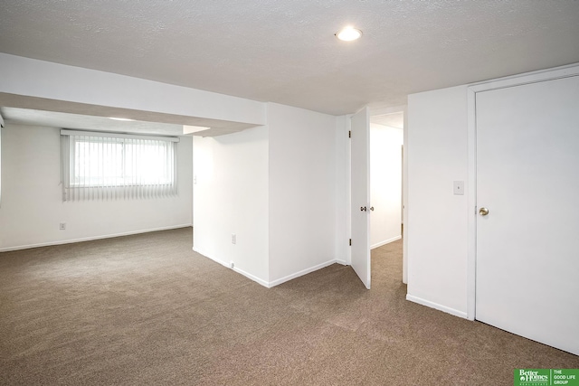 basement with carpet floors, a textured ceiling, and baseboards