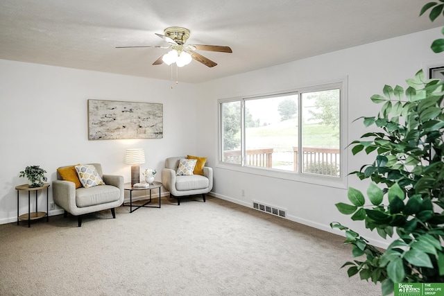 sitting room with visible vents, a ceiling fan, baseboards, and carpet flooring