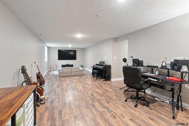 home office featuring a textured ceiling, baseboards, and wood finished floors