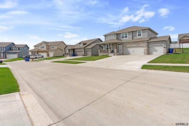 view of front of home featuring a residential view, stone siding, driveway, a front lawn, and an attached garage