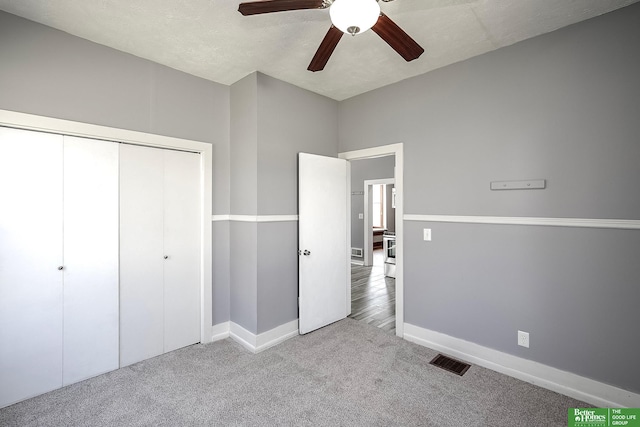 unfurnished bedroom featuring a ceiling fan, visible vents, baseboards, a closet, and carpet flooring
