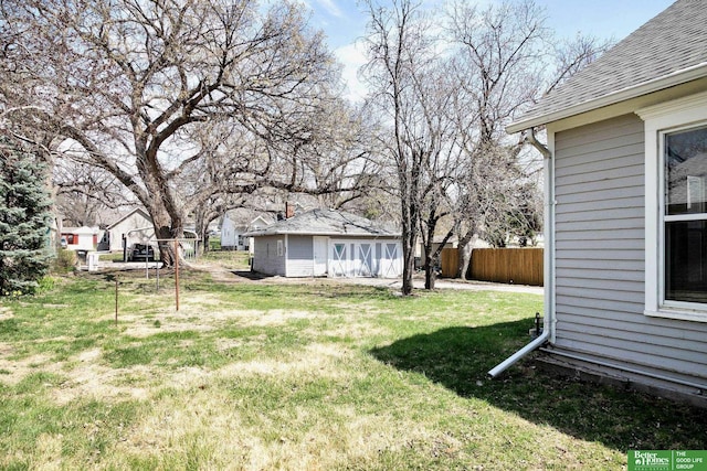 view of yard with fence and an outbuilding