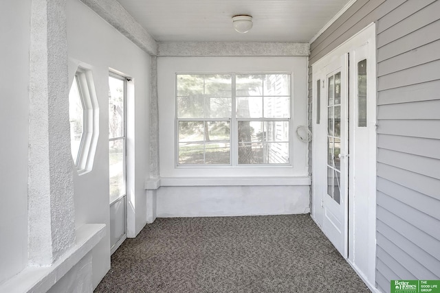 unfurnished sunroom with carpet flooring