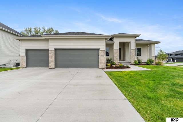 prairie-style house featuring a garage, driveway, and a front yard