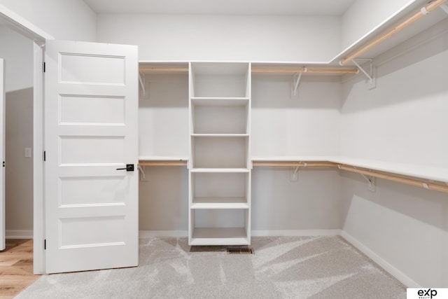 walk in closet with visible vents and carpet