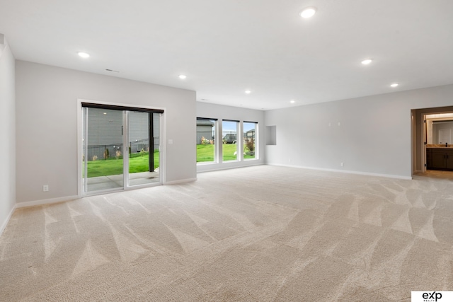spare room featuring recessed lighting, baseboards, and light colored carpet