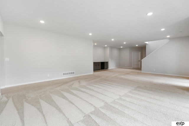 basement featuring recessed lighting, baseboards, visible vents, and light carpet