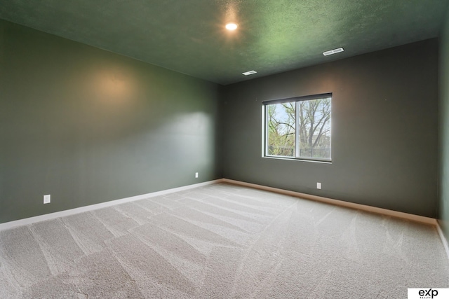 carpeted spare room featuring baseboards and recessed lighting