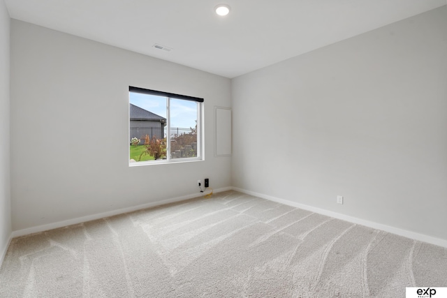 unfurnished room with baseboards, visible vents, and light colored carpet