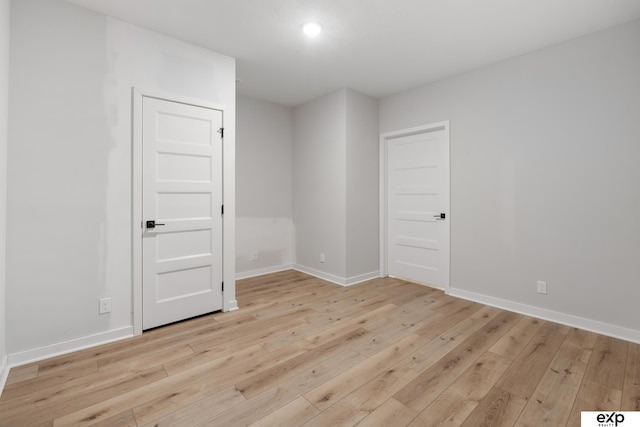 unfurnished room with light wood-style floors, baseboards, and recessed lighting