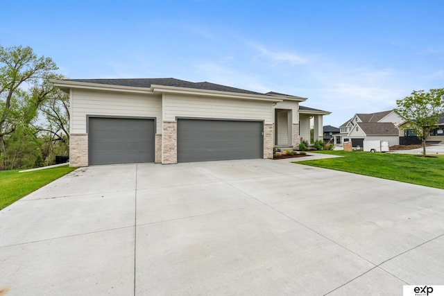 prairie-style home with a garage, concrete driveway, and a front yard