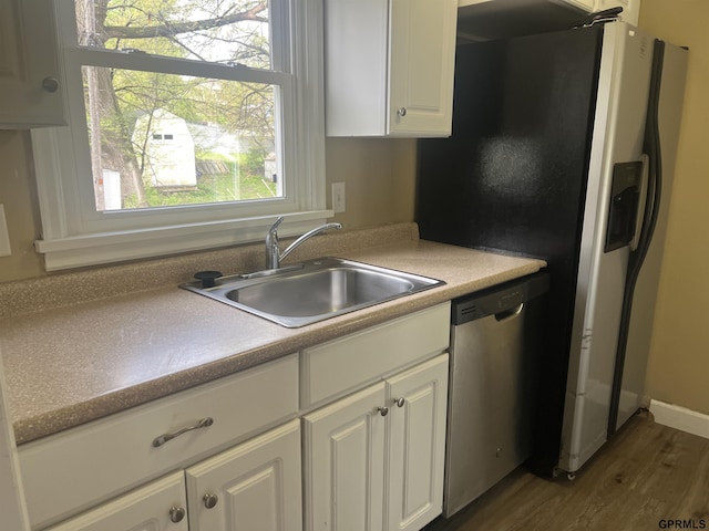 kitchen featuring dishwasher, a sink, light countertops, white cabinets, and dark wood-type flooring