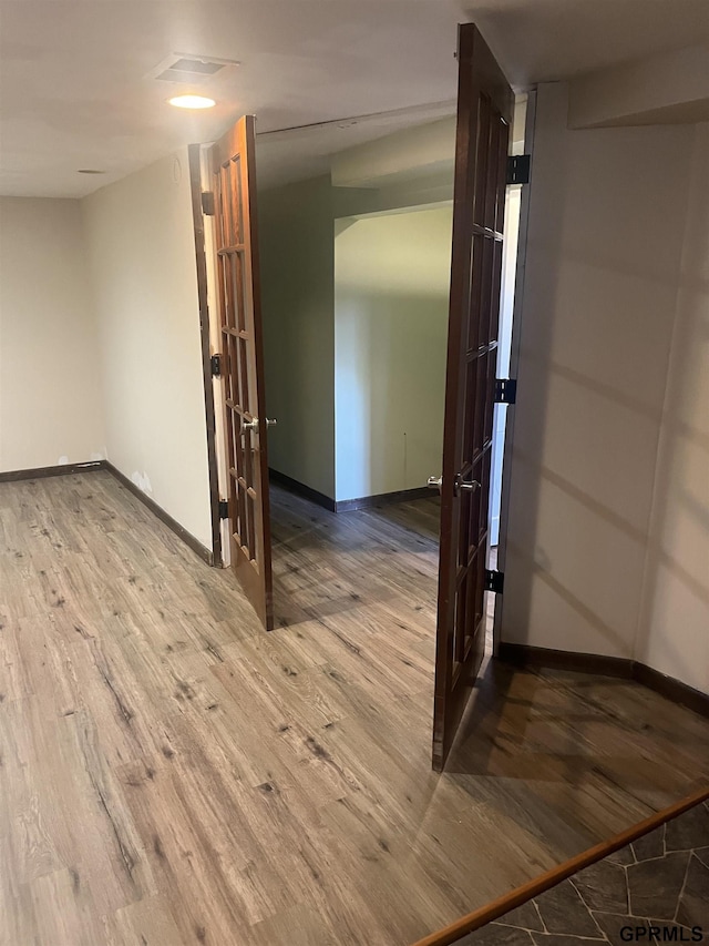 interior space with baseboards, visible vents, and wood finished floors