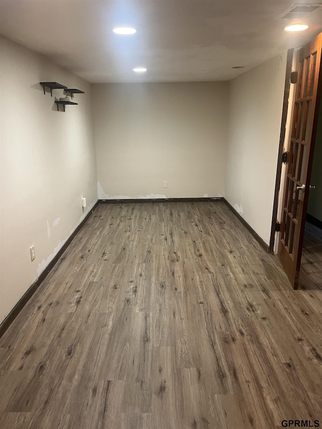 finished below grade area featuring baseboards and wood finished floors