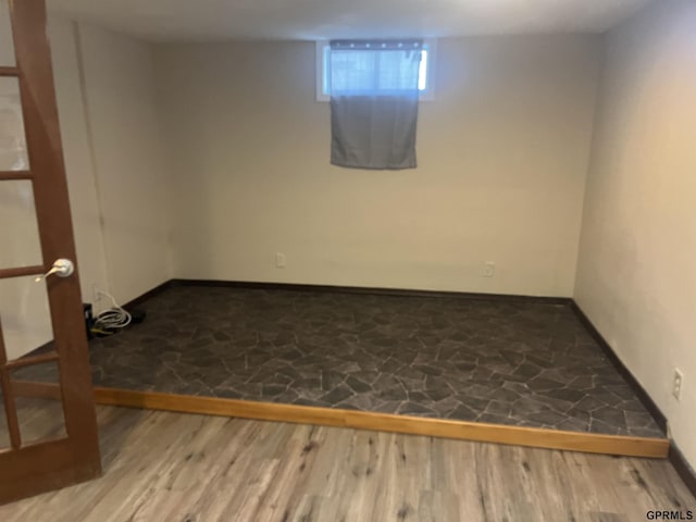 basement featuring baseboards and wood finished floors