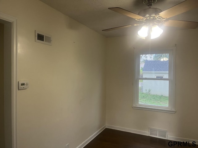 unfurnished room with baseboards, ceiling fan, dark wood-style flooring, and visible vents
