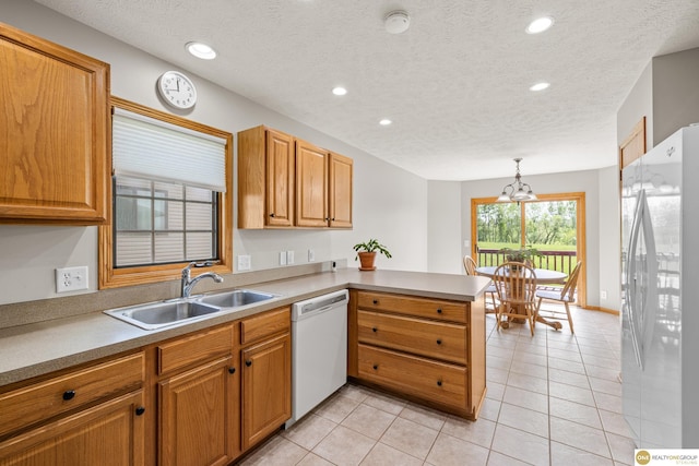 554 Shawnee Blvd, Tecumseh, NE 68450 - kitchen featuring white appliances, a sink, a peninsula, light tile patterned floors, and recessed lighting