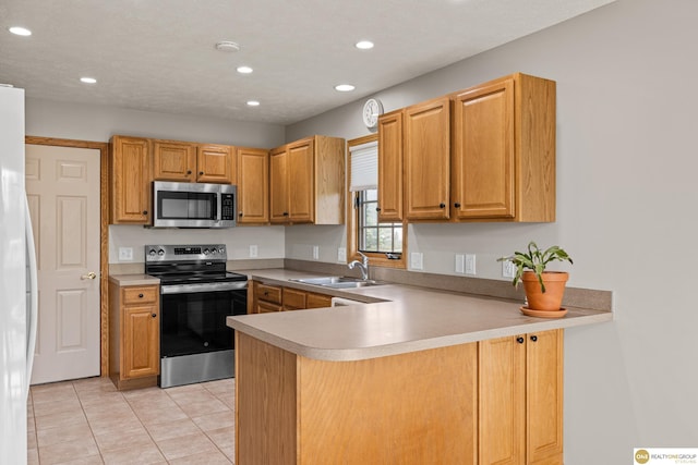 554 Shawnee Blvd, Tecumseh, NE 68450 - kitchen with stainless steel appliances, a sink, a peninsula, light tile patterned floors, and recessed lighting