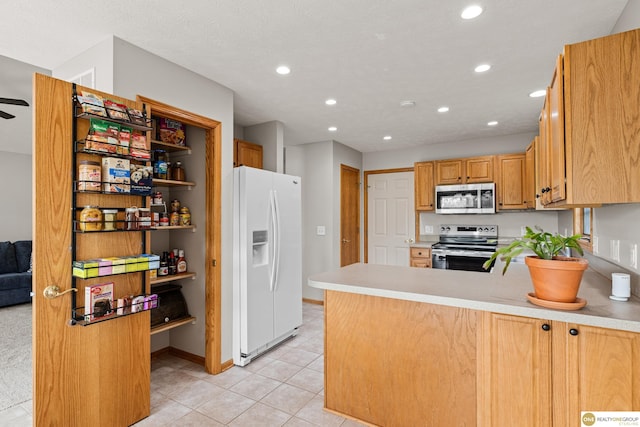 554 Shawnee Blvd, Tecumseh, NE 68450 - kitchen with appliances with stainless steel finishes, recessed lighting, light tile patterned floors, a peninsula, and light countertops
