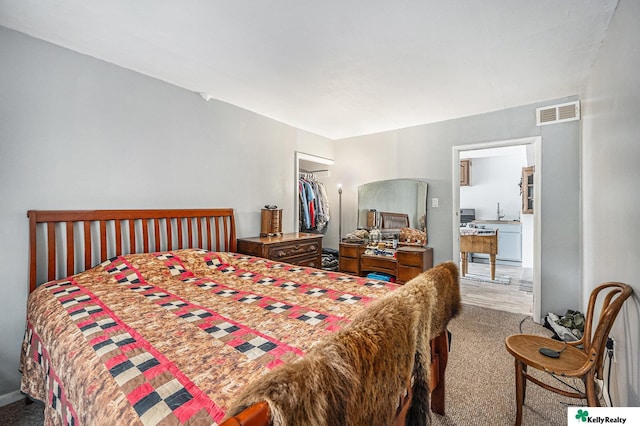 bedroom featuring visible vents, carpet flooring, a walk in closet, and a closet