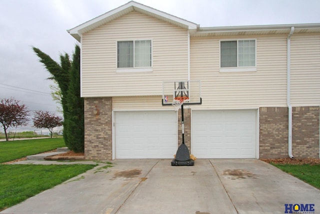 5201 N 9th Cir, Lincoln, NE 68521 - view of front of home with brick siding, a garage, a front yard, and concrete driveway