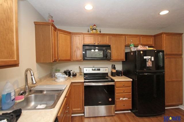 5201 N 9th Cir, Lincoln, NE 68521 - kitchen featuring light countertops, a sink, black appliances, and wood finished floors