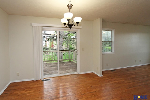 5203 N 9th Cir, Lincoln, NE 68521 - unfurnished dining area featuring visible vents, a notable chandelier, wood finished floors, and a wealth of natural light