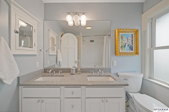 full bathroom featuring toilet, a wealth of natural light, and a sink