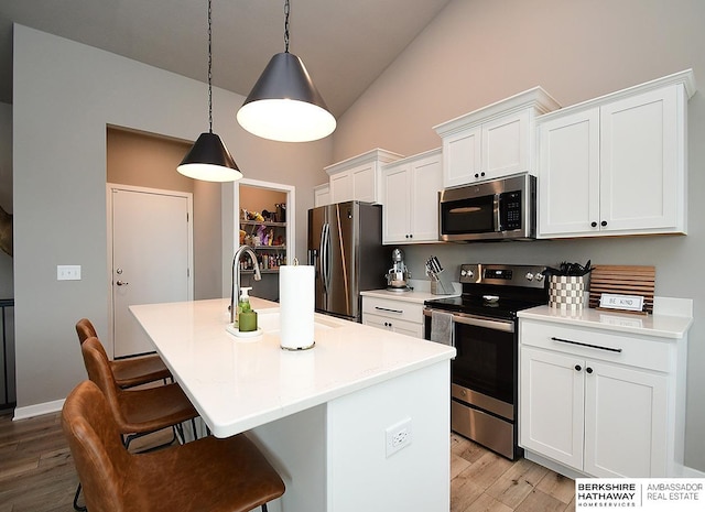 7911 N 149th St, Bennington, NE 68007 - kitchen featuring light wood finished floors, a kitchen island with sink, appliances with stainless steel finishes, and high vaulted ceiling