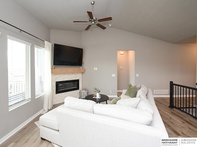 7911 N 149th St, Bennington, NE 68007 - living area with vaulted ceiling, a fireplace, ceiling fan, and wood finished floors