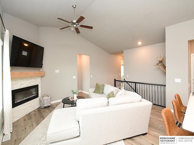 7911 N 149th St, Bennington, NE 68007 - living area with light wood-style floors, vaulted ceiling, a ceiling fan, and a stone fireplace