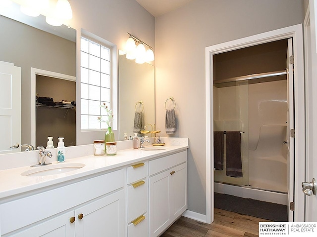 7911 N 149th St, Bennington, NE 68007 - full bathroom with double vanity, wood finished floors, a stall shower, and a sink