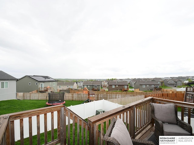 7911 N 149th St, Bennington, NE 68007 - wooden deck with a trampoline, a residential view, a lawn, and a fenced backyard