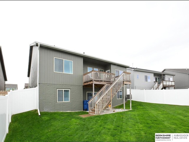 7911 N 149th St, Bennington, NE 68007 - rear view of house with a lawn, brick siding, fence, stairs, and a deck