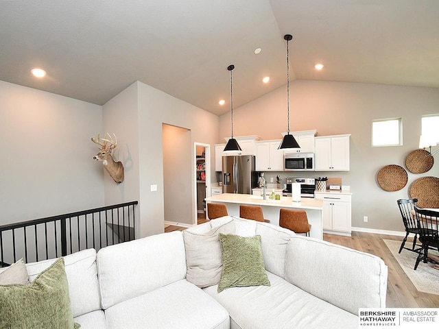7911 N 149th St, Bennington, NE 68007 - living area featuring baseboards, recessed lighting, light wood-style floors, and high vaulted ceiling