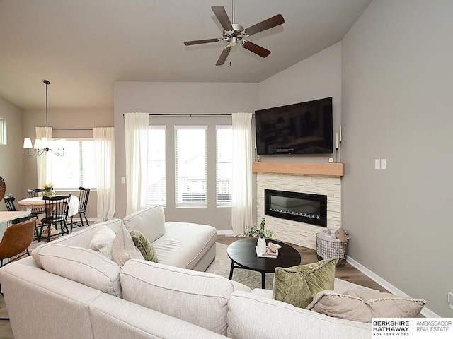 7911 N 149th St, Bennington, NE 68007 - living area featuring wood finished floors, ceiling fan with notable chandelier, a fireplace, baseboards, and lofted ceiling