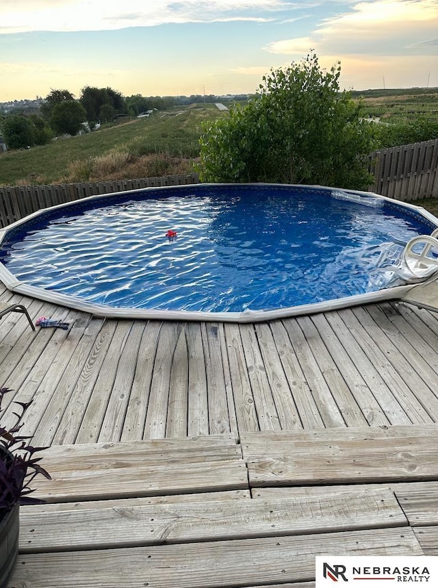 pool at dusk with a wooden deck