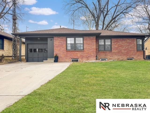 1816 S 49th St, Lincoln, NE 68506 - view of front of home with concrete driveway, brick siding, an attached garage, and a front yard