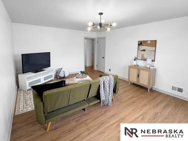 1816 S 49th St, Lincoln, NE 68506 - living area featuring visible vents, light wood finished floors, baseboards, and an inviting chandelier