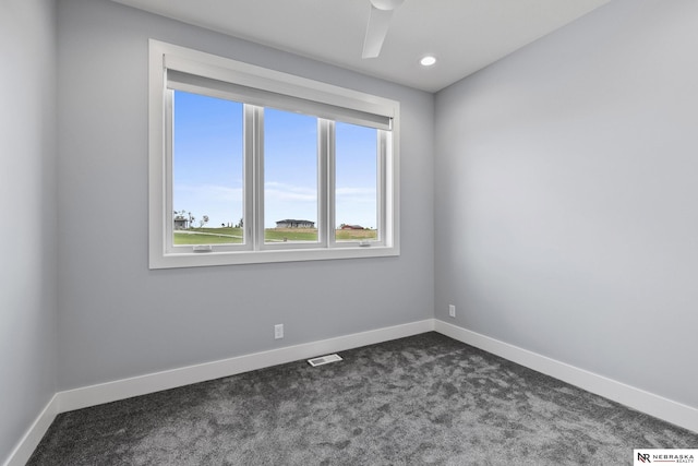empty room featuring recessed lighting, baseboards, dark colored carpet, and visible vents