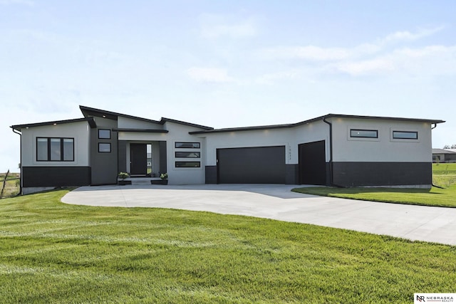 view of front of property with a garage, driveway, a front lawn, and stucco siding